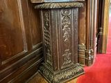 une statue représentant un homme debout derrière un pupitre dans une pièce