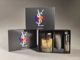 two bottles of perfume in a black box on a table