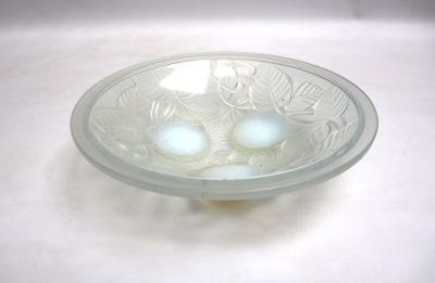 un saladier en verre contenant trois œufs, posé sur une surface blanche