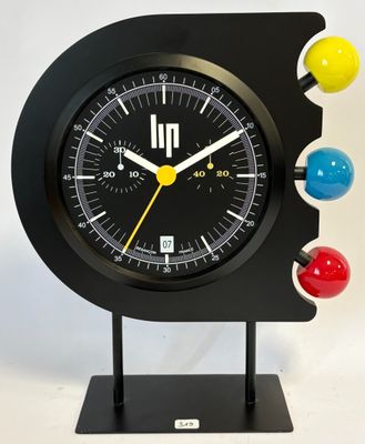 a black clock with multi colored balls on it