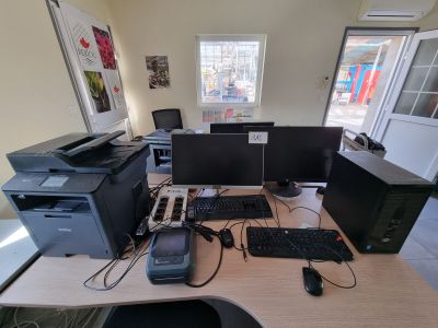 a desk with two computers and a printer on it