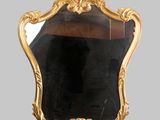a mirror that has a gold frame on it