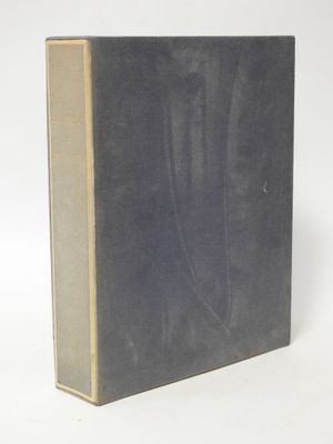 an old book sitting on top of a white table next to a white wall