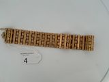 a gold bracelet on a white plate with a number 4 on it