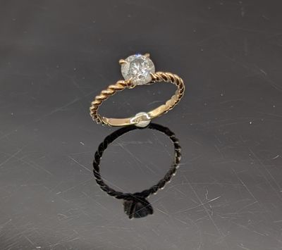 une photo d'une bague en diamant posée sur un fond noir