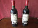 two bottles of wine sitting on a wooden table