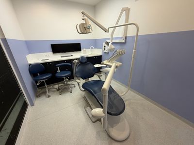 a dentist ' s chair in the corner of the room