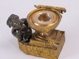 a small statue of a boy sitting on a box with a candle