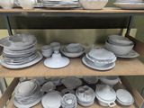 many plates and bowls on a shelf in a store