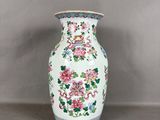 un vase blanc avec des fleurs posé sur une table