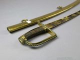 an image of a sword with a gold handle on a white surface