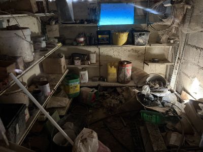 an image of a dirty kitchen with a tv in the corner