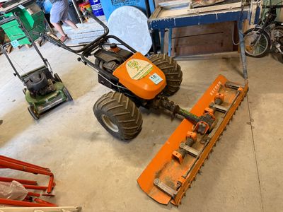 un homme qui répare une tondeuse à gazon dans le garage