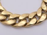 a close up of a gold chain necklace on a white surface