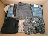une boîte en carton remplie de jeans et d'autres vêtements