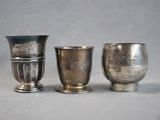 three silver cups sitting next to each other on a table