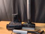 a table with a lamp, a cell phone, and other items on it