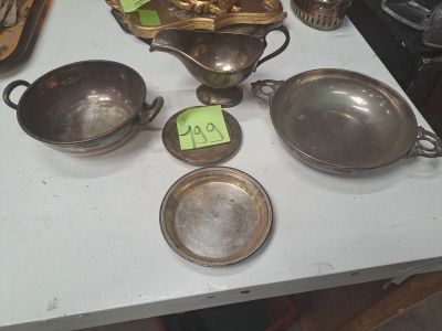 beaucoup d'argenterie sur une table, avec une étiquette de prix