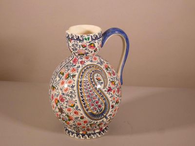 un vase orné d'un motif paisley, posé sur une table