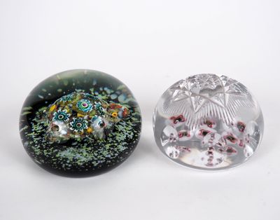 two glass paperweightes sitting next to each other on a white surface