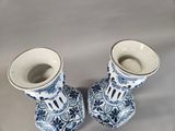 pair of blue and white vases sitting on top of a table