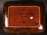 a brown plate with writing on it on a black surface