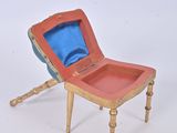 a small wooden chair with a blue cushion on it