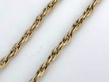 a close up of two gold chains on a white surface