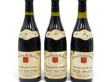 trois bouteilles de vin sont alignées sur une surface blanche