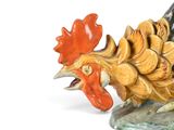 a figurine of a rooster on a rock