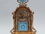 a gold and blue clock sitting on top of a table