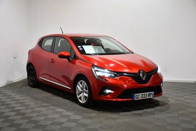 une voiture rouge est garée dans une pièce au sol en damier