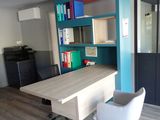 a desk with a chair and a book shelf in the corner