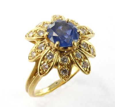 Gros plan sur une bague en or ornée d'un saphir bleu et de diamants