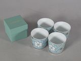 quatre tasses posées à côté d'une boîte sur une table