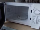 a microwave sitting on top of a shelf next to a microwave oven