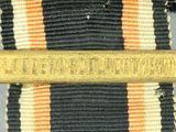 a gold medal on a black and white striped tie