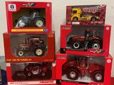 three boxed toy tractors are sitting on a red table