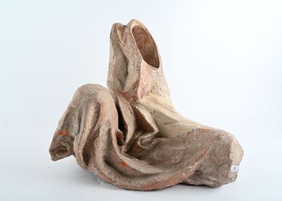 statue représentant une femme assise sur un rocher, les jambes croisées
