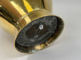 a gold vase that is sitting on a white surface