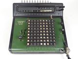 an old calculator sitting on top of a white table