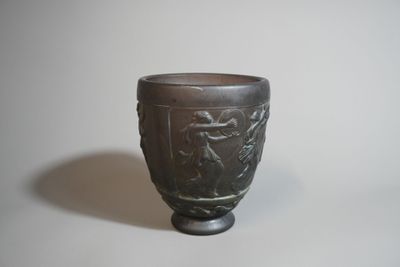 un vase noir orné d'un motif, posé sur une table
