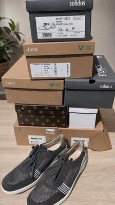 three boxes of shoes are stacked on top of each other on a table