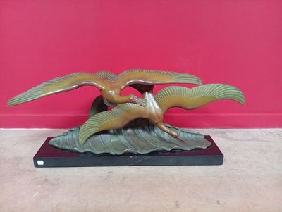 une image représentant une sculpture en bronze de deux oiseaux posés sur un rocher