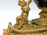 a black vase with a gold decoration on top of it