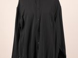une chemise noire posée sur un mannequin, sur fond blanc