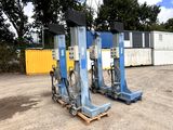 deux crics hydrauliques posés sur des palettes dans un parking