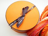 an orange box with a black ribbon tied to it