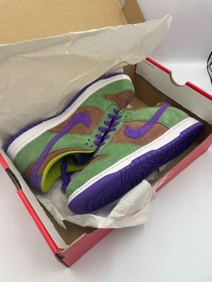 purple and green sneakers are in a box on a white surface