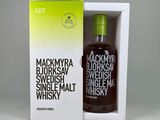 the bottle of whisky is in a white box with a green lid